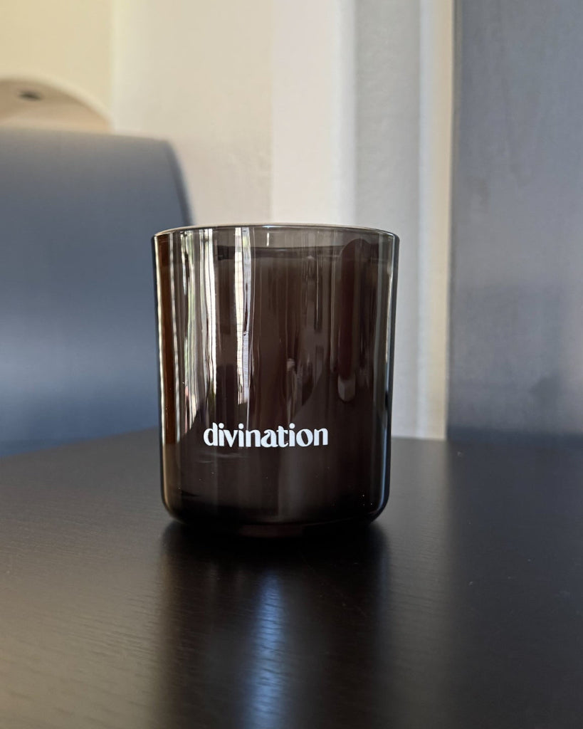 Divination 9 oz double-wick candle in a smoked black glass vessel.