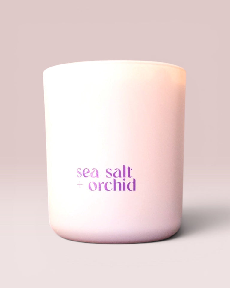 Sea Salt + Orchid 9 oz double-wick candle in a matte blush glass vessel.