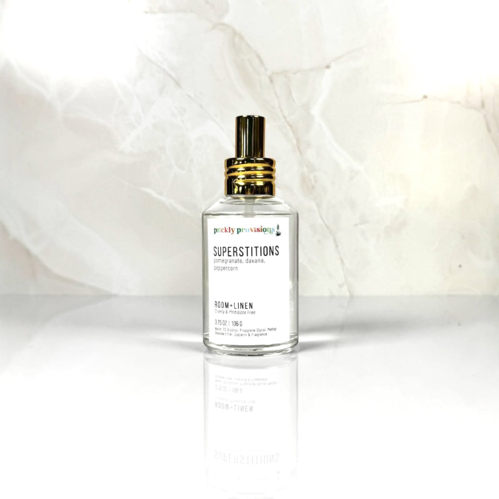 Arizona Sunset 4 oz room and linen spray in a clear glass bottle with a polished gold sprayer.