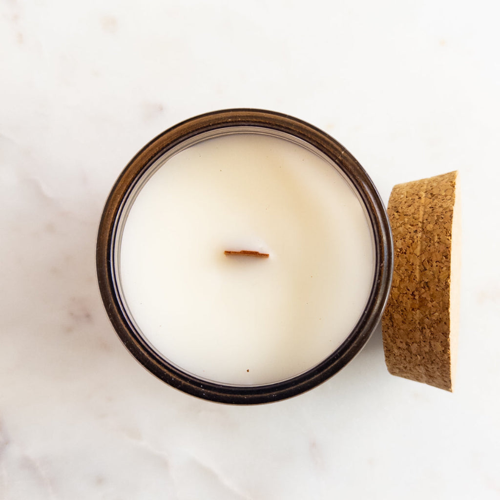 Unbothered 7.5 oz wood-wick candle in a recycled-glass vessel.