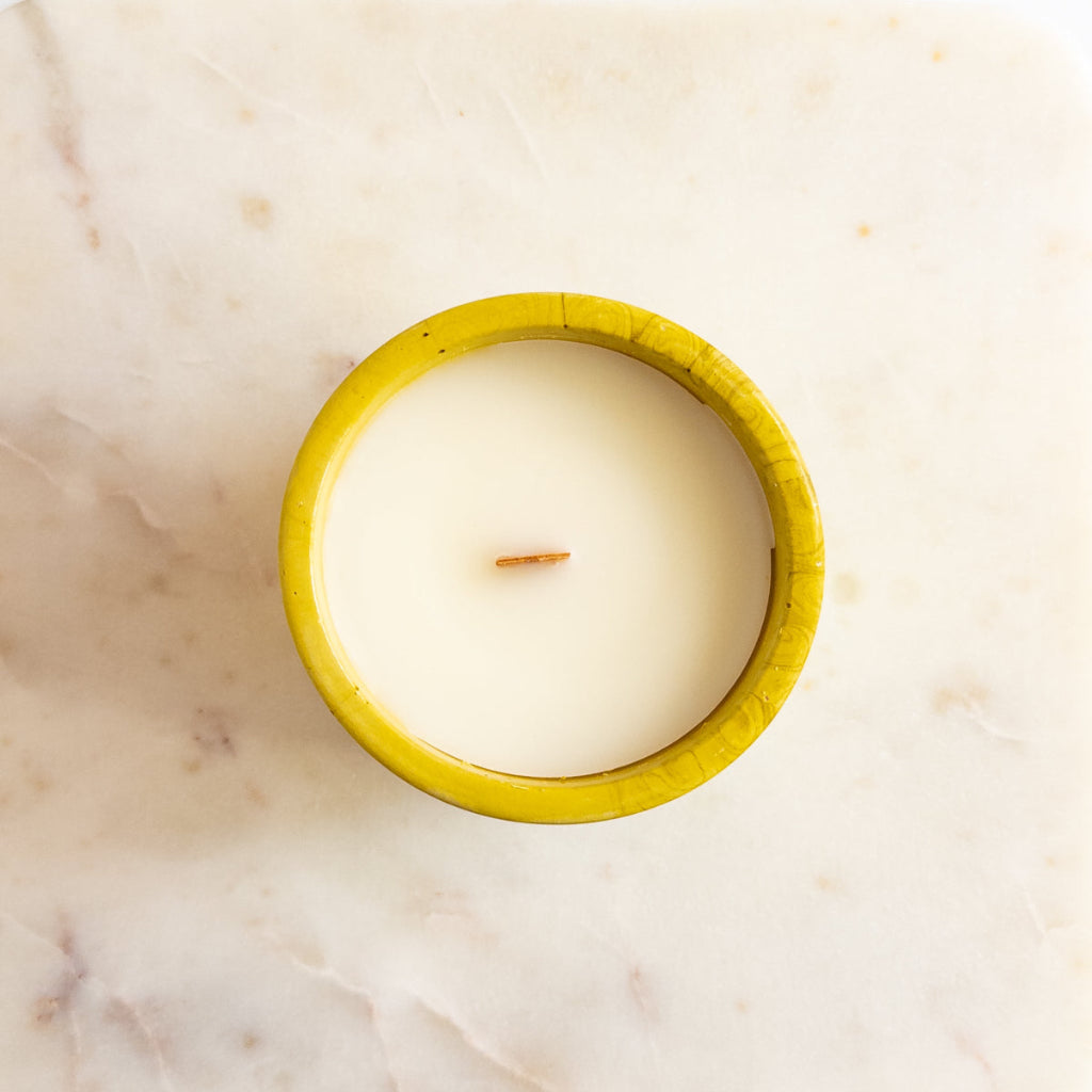 White Tea + Thyme 8 oz candle in a green swirled cement vessel with matching lid.
