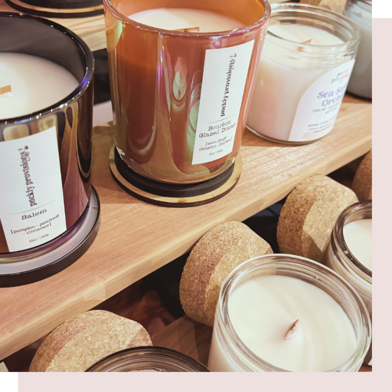 Candles with labels on a wooden shelf and surface