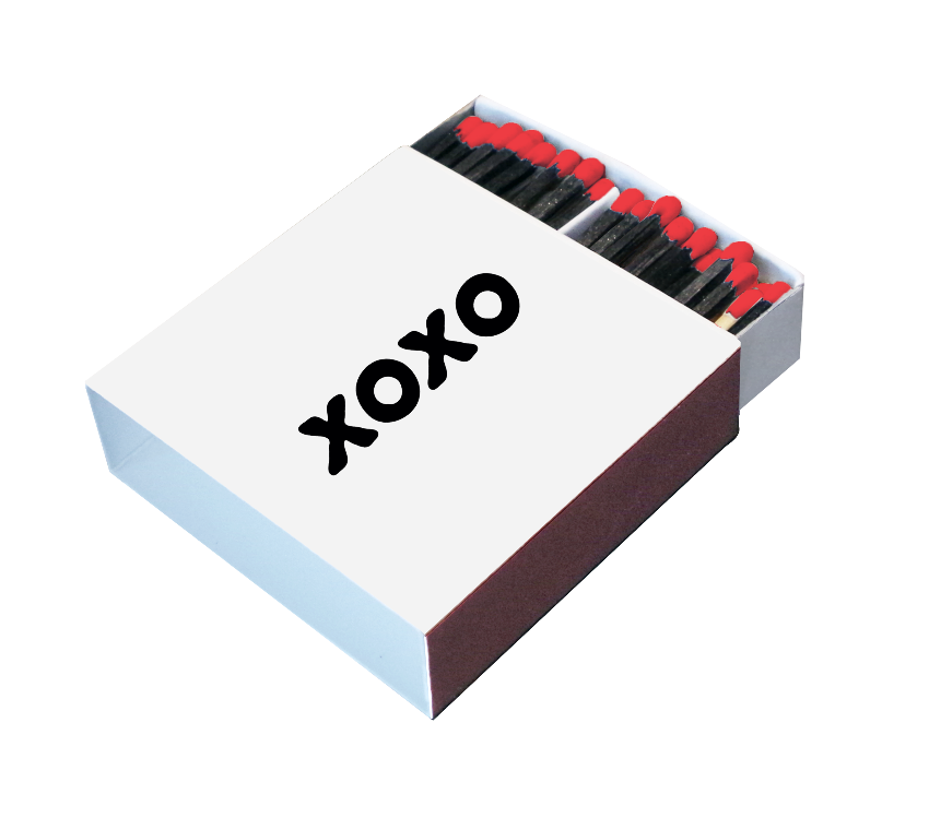 Angled view of a white XOXO matchbox with black matches and bright red tips

