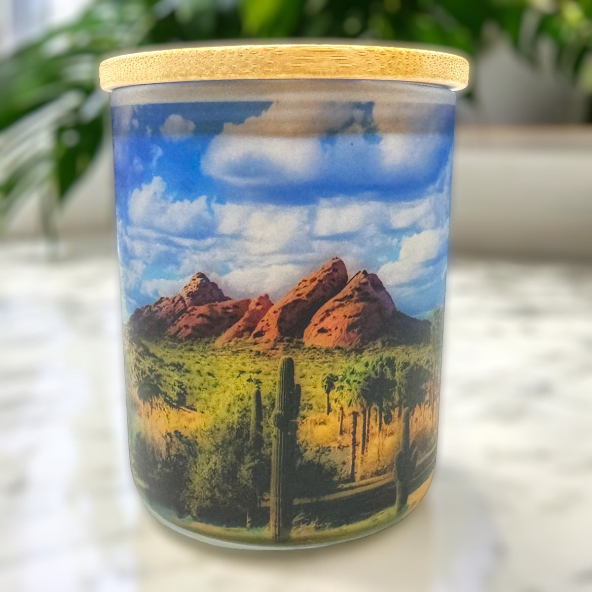 Candle with a desert landscape design on a white surface