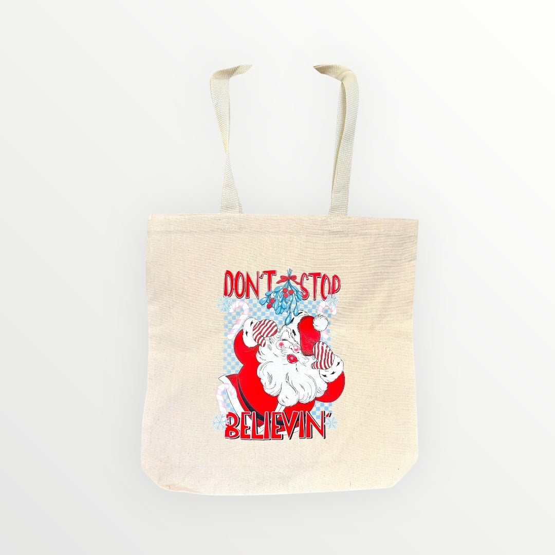 Tote bag with Santa Claus graphic and text 'Don't Stop Believin'' on a white background