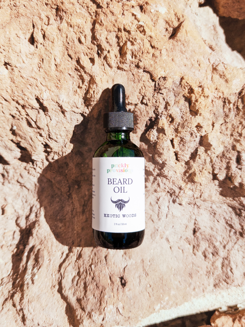 Bottle of Exotic Woods beard oil on a textured stone surface