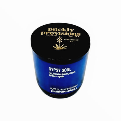 Blue candle jar with black lid featuring 'prickly provisions' branding on a white background