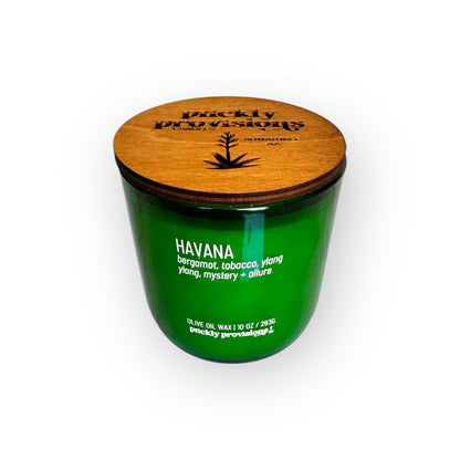Green candle with wooden lid labeled 'Havana' by Puckly Provisions on a white background