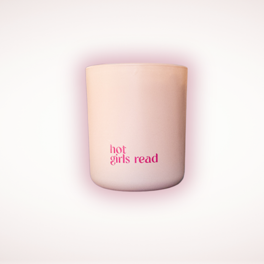 Blush candle with 'hot girls read' text on a light pink background