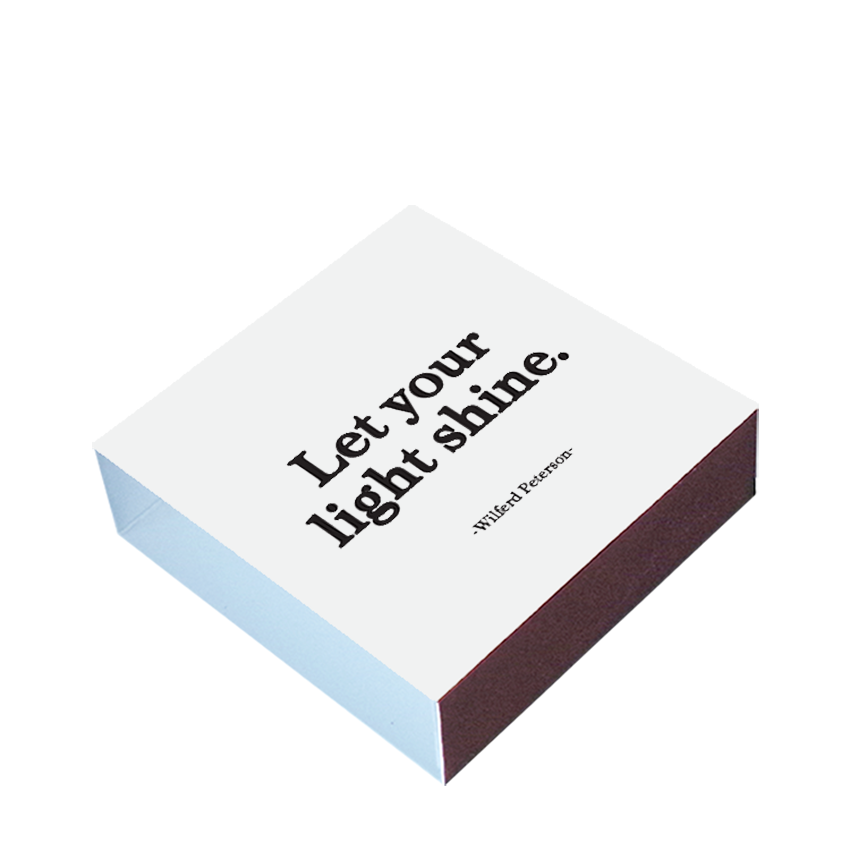 Matchbox with 'Let your light shine' text on a white background