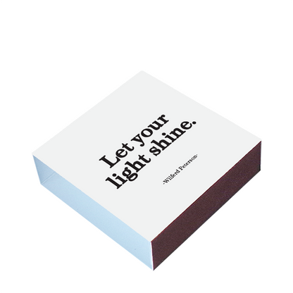 Matchbox with 'Let your light shine' text on a white background