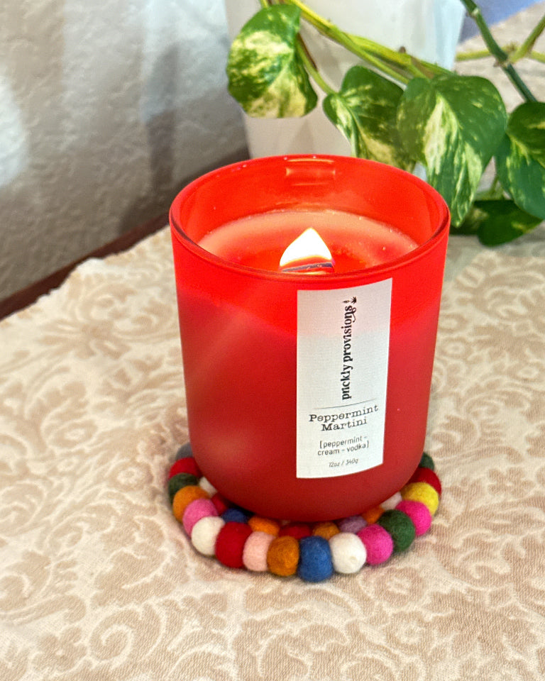 Prickly Provisions candle displayed on a multicolored felted wool coaster