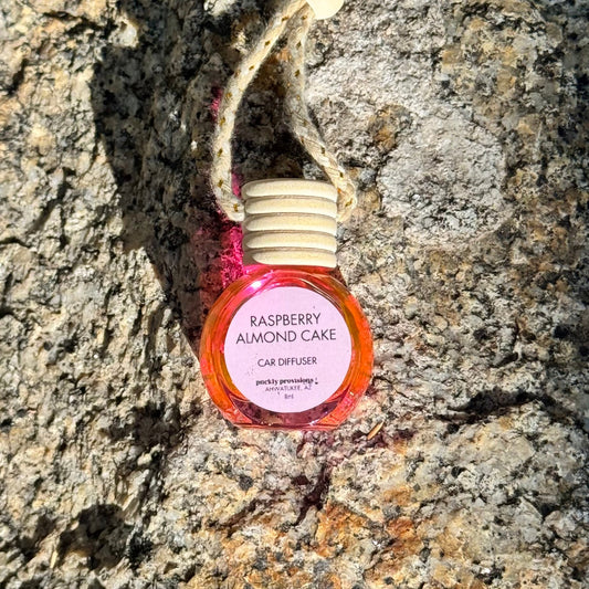 Raspberry Almond Cake car diffuser on a textured stone