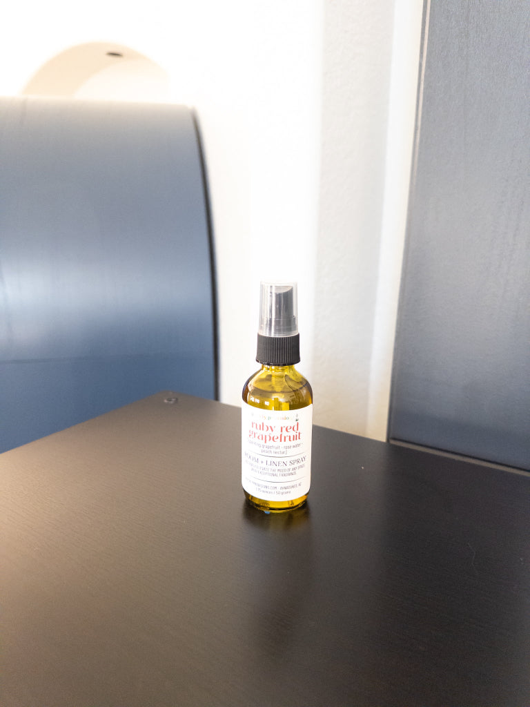 Ruby Red Grapefruit 2 oz room and linen spray in a transparent green bottle with black sprayer