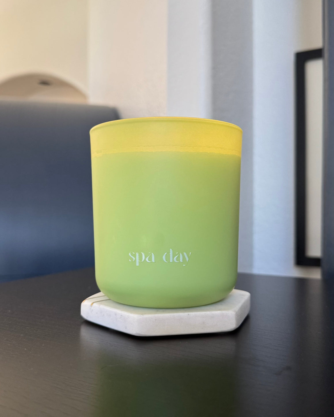 Spa Day Citrus Mint Oakmoss Wood Wick green Candle labeled 'spa day' on a table with a blurred background