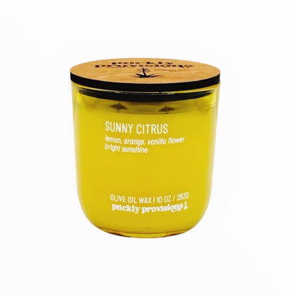 Yellow candle with wooden lid labeled 'Sunny Citrus' on a white background