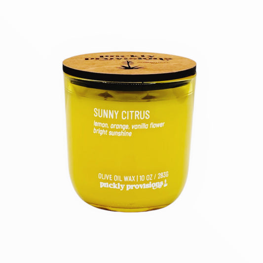 Yellow candle with wooden lid labeled 'Sunny Citrus' on a white background
