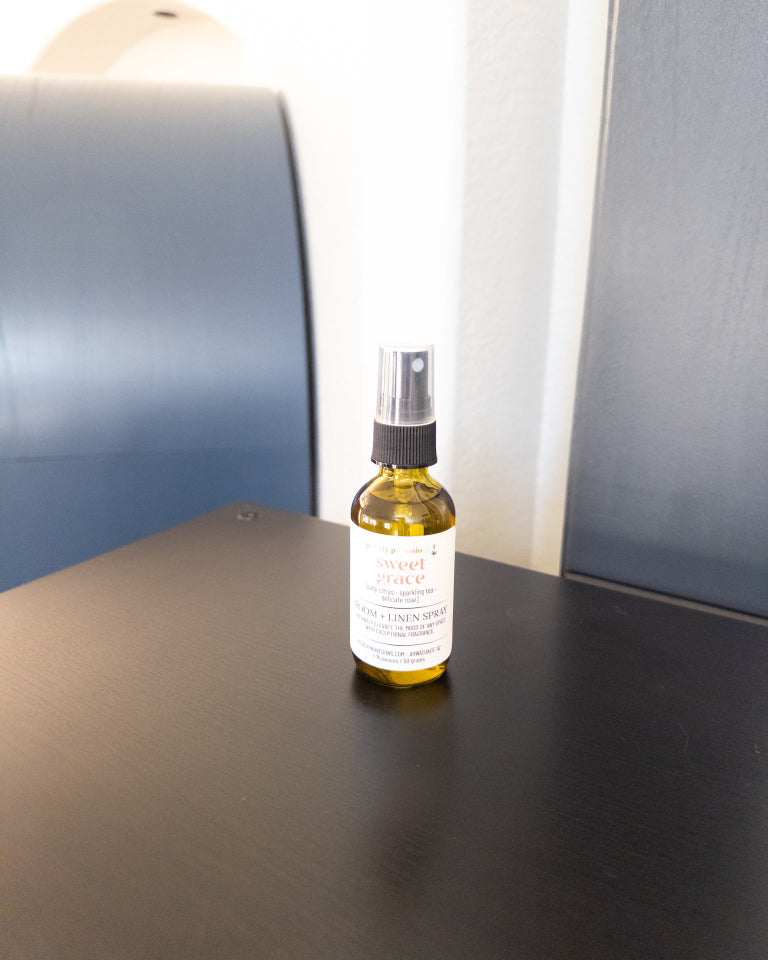 Sweet Grace 2 oz room and linen spray in a transparent green bottle with a black sprayer