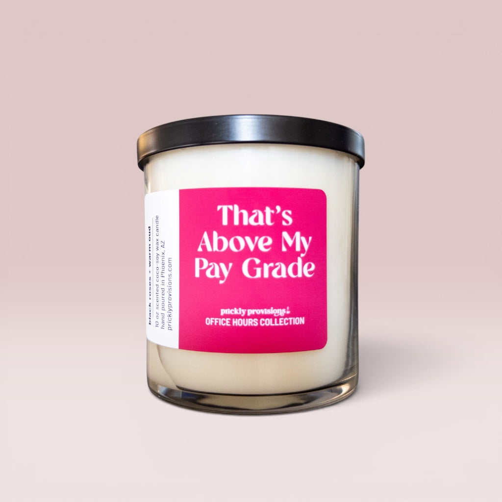 That’s Above My Pay Grade 10 oz double-wick office candle with a bright pink label and black metal lid.