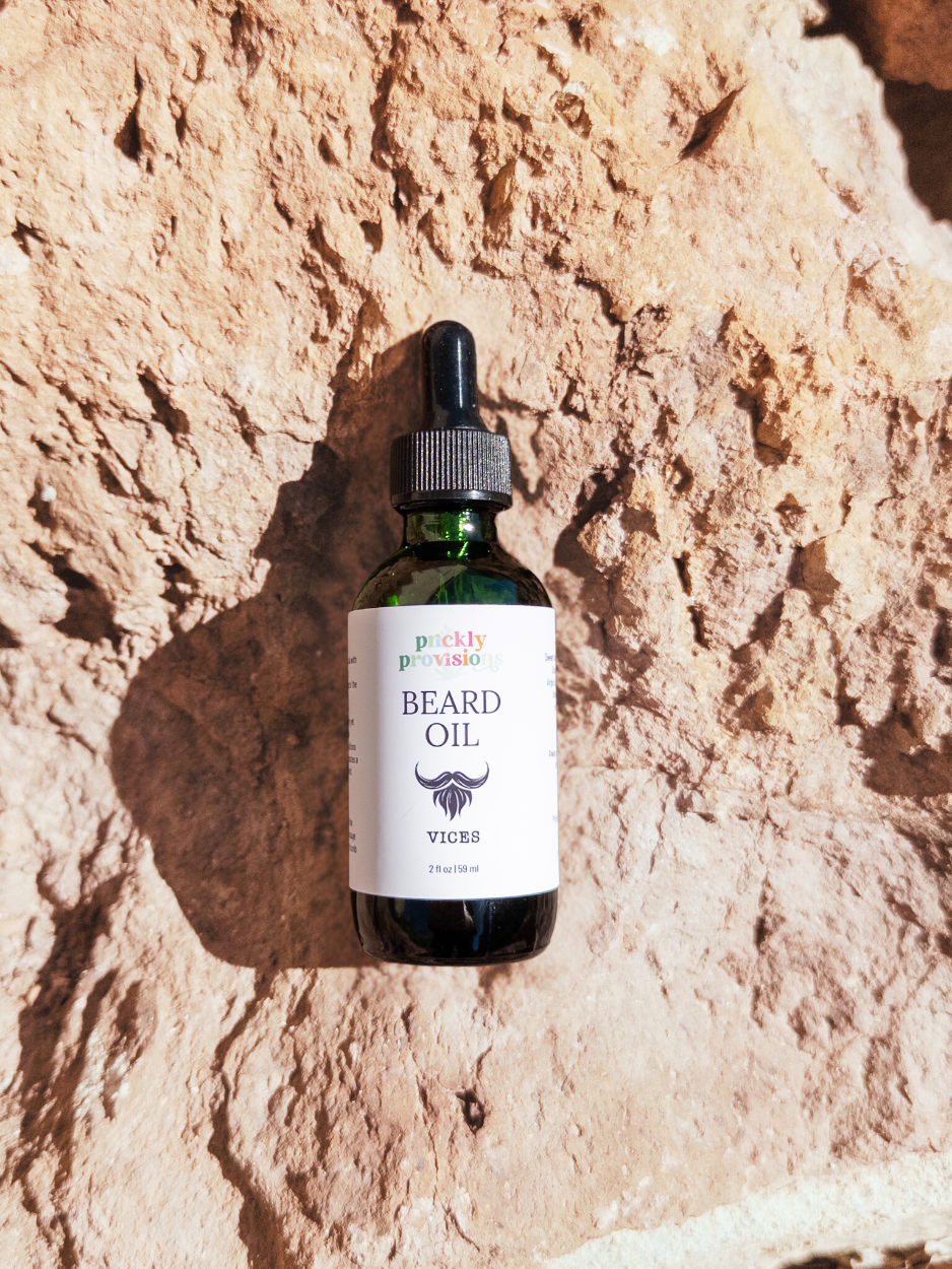 Bottle of beard oil with a dropper on a textured stone background