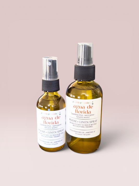 Agua de Florida 2 oz and 4 oz room and linen spray in a transparent green bottle with a black sprayer.