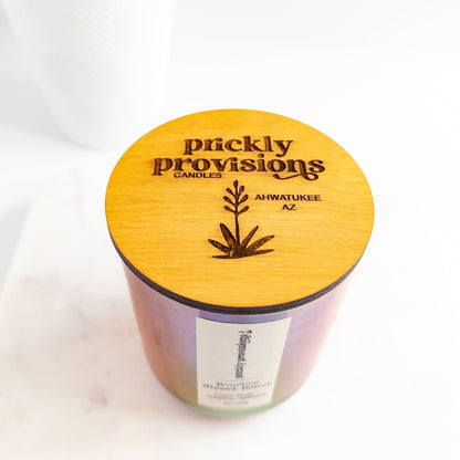 Candle with 'Prickly Provisions' branding on a white background