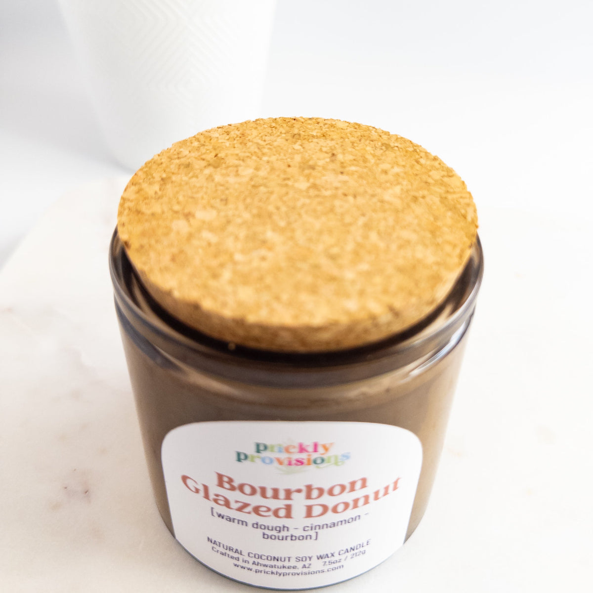 Jar of 'Bourbon Glazed Donut' candle with cork lid on a white background