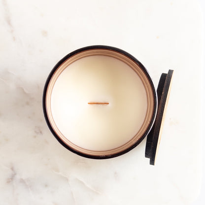 Candle in a copper container on a marble surface