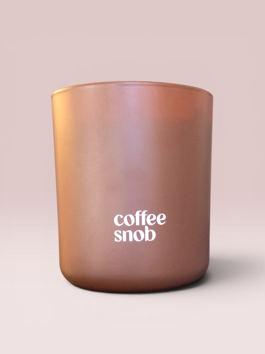 Coffee Snob 9 oz double-wick candle in a matte brown glass vessel.