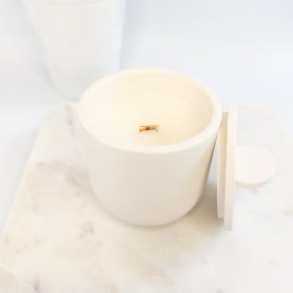 White candle in a cement holder on a light background