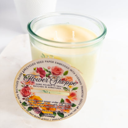 Candle in a glass jar with a decorative label on a white background