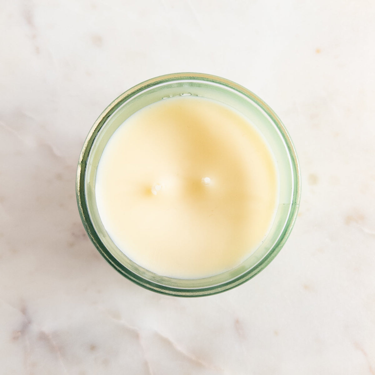 Candle in a glass jar on a marble surface