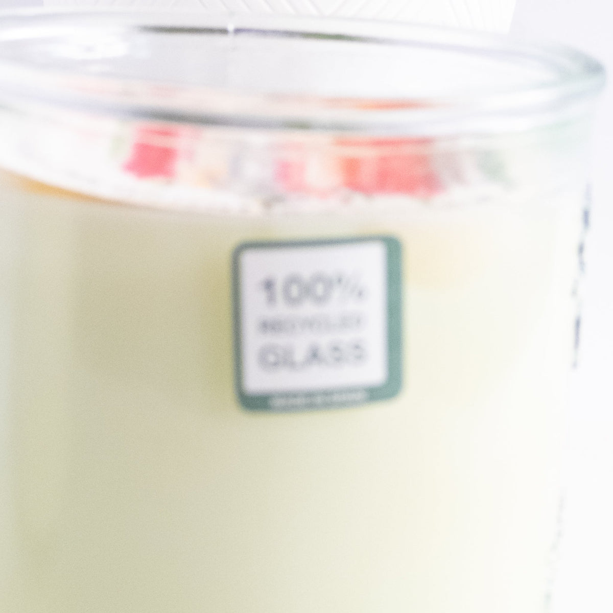 Clear glass container with a label indicating 100% recycled glass.