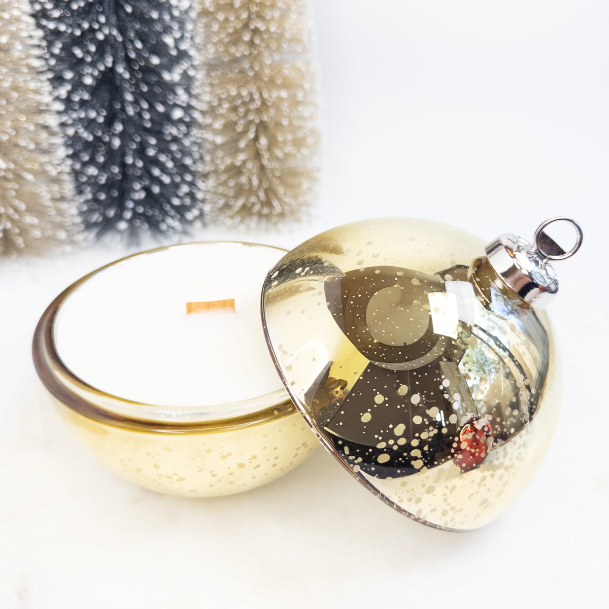 Decorative glass ornament with gold base on a white background
