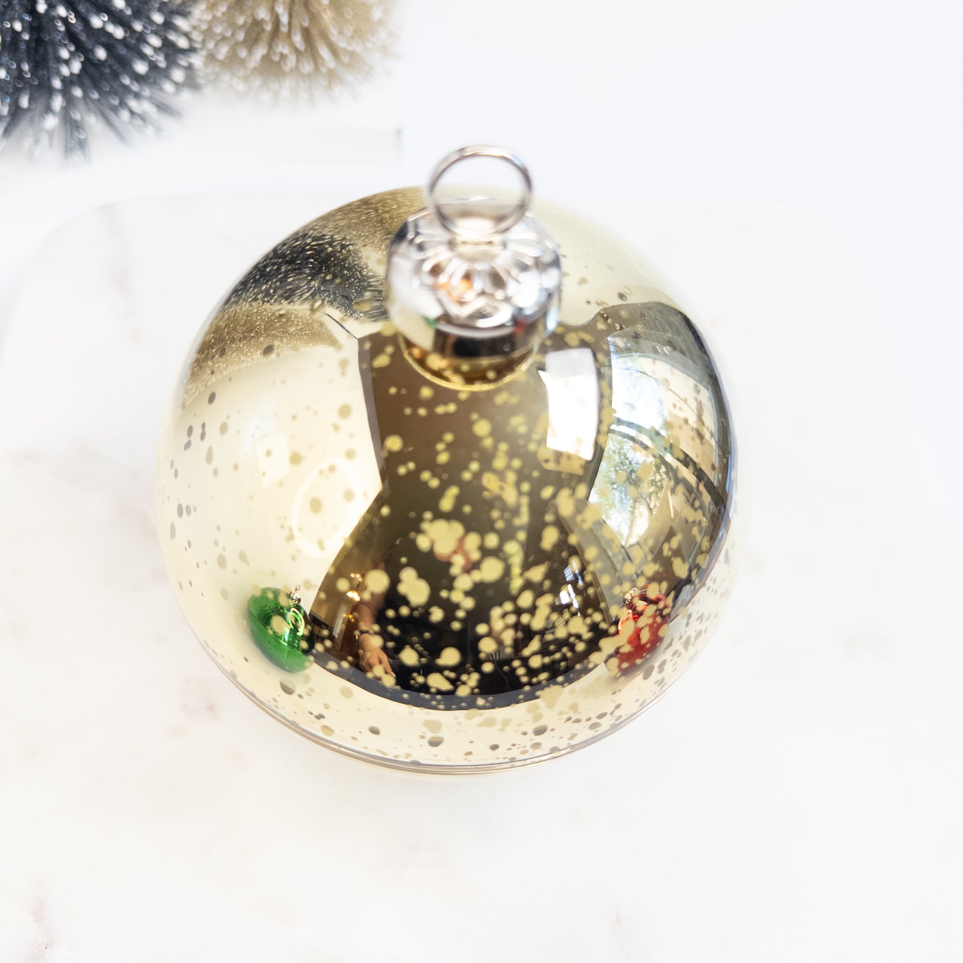 Decorative glass ornament with gold speckles on a white background