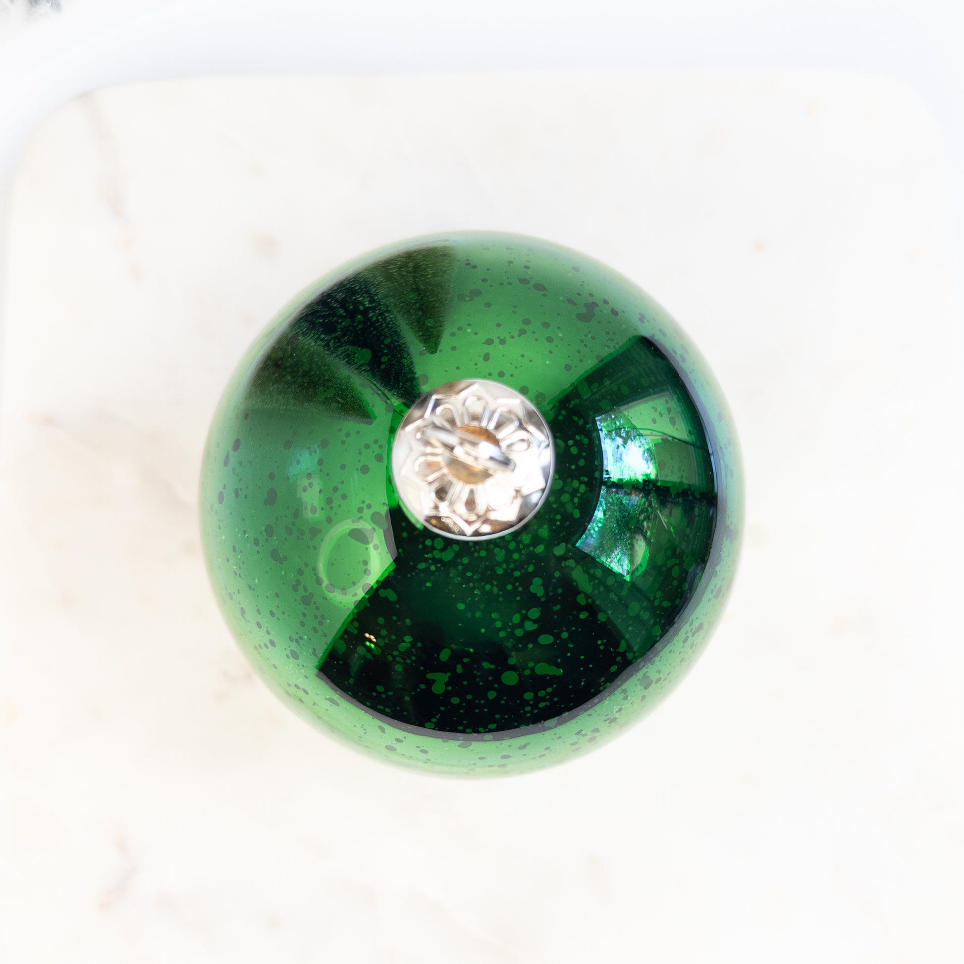 Green Christmas ornament candle on a white background