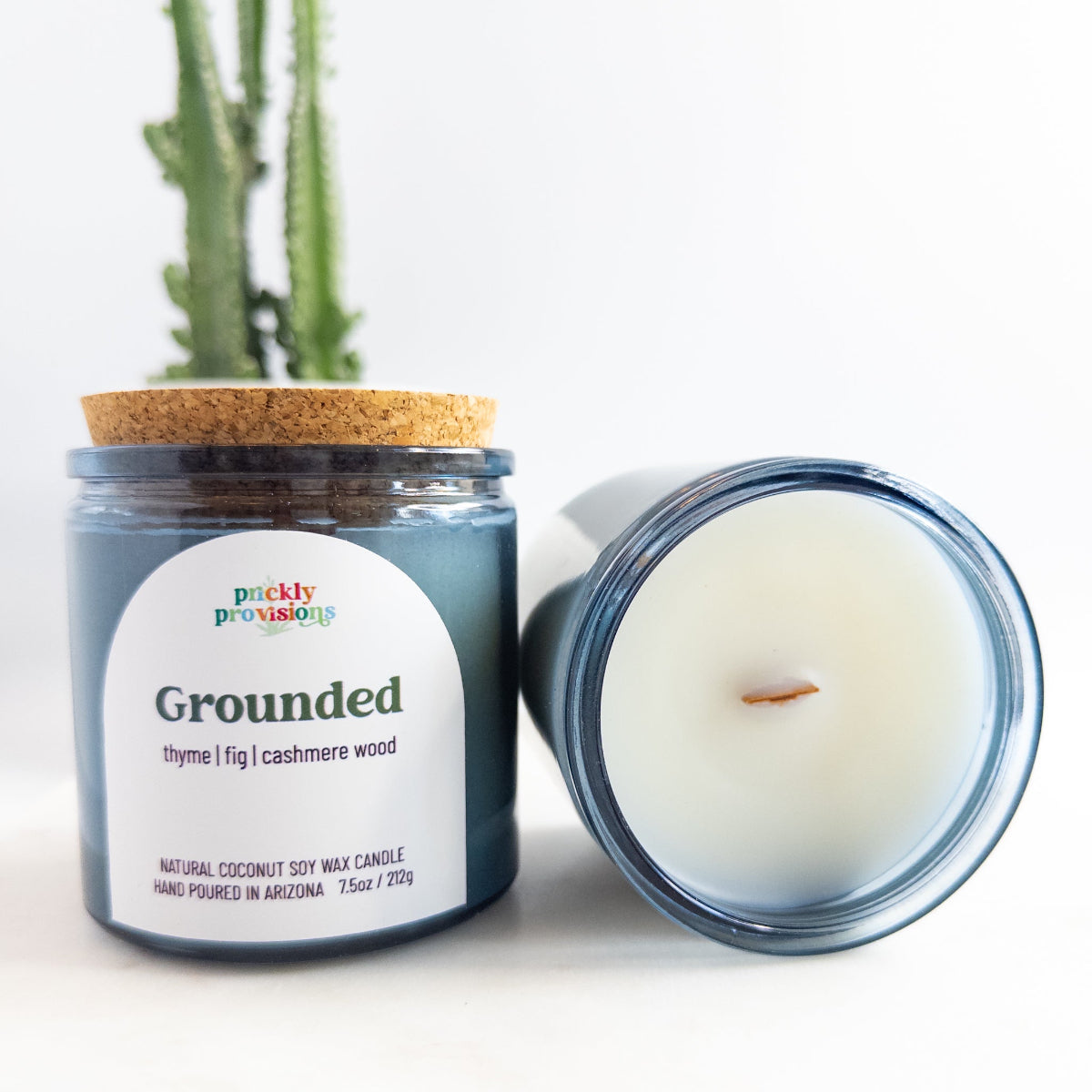 Candle jar labeled 'Grounded' by Prickly Provisions with a cactus in the background.
