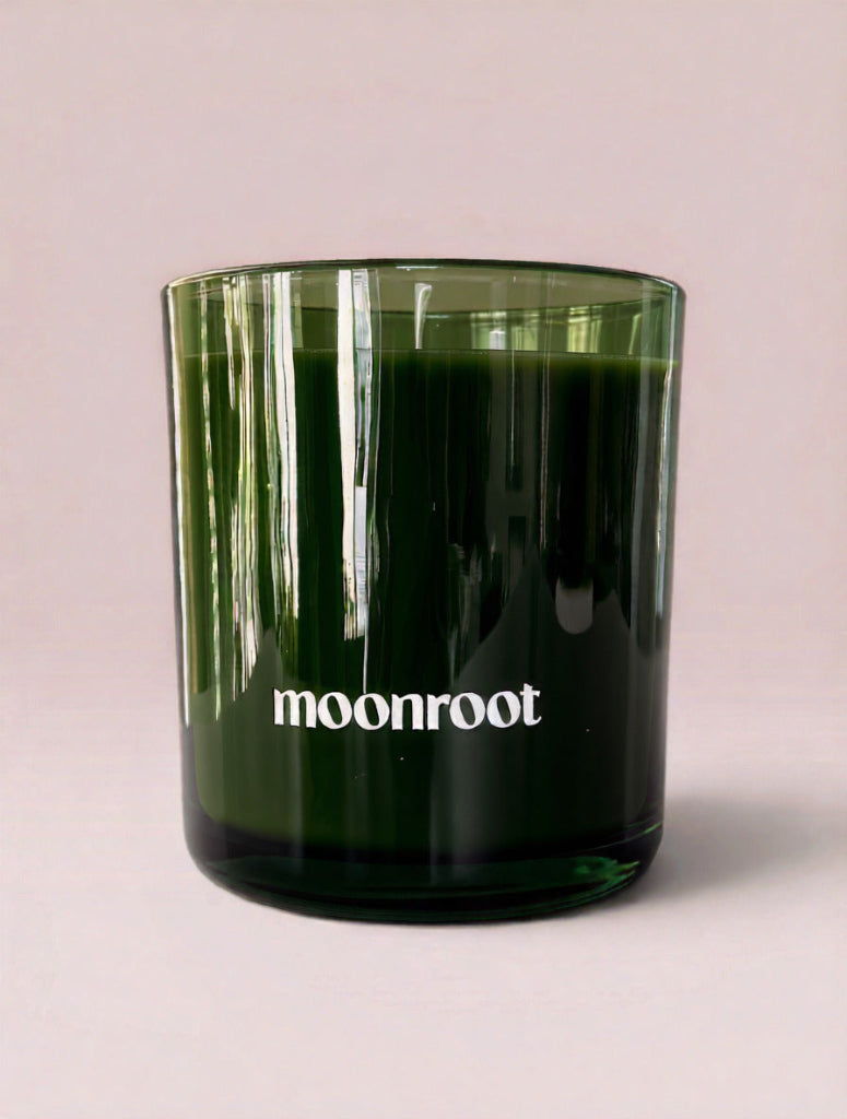 Moonroot 9 oz double-wick candle in translucent deep green glass