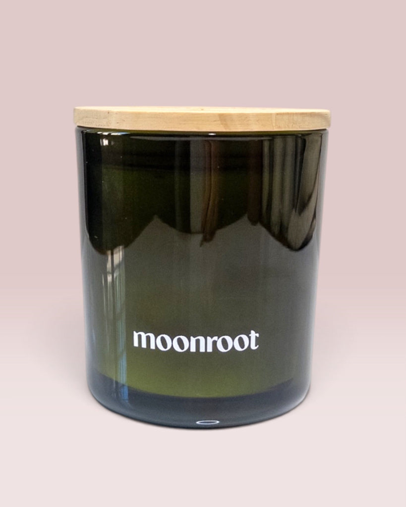 Moonroot 9 oz double-wick candle in translucent deep green glass