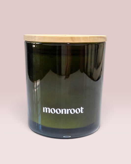 Moonroot 9 oz double-wick candle in translucent deep green glass