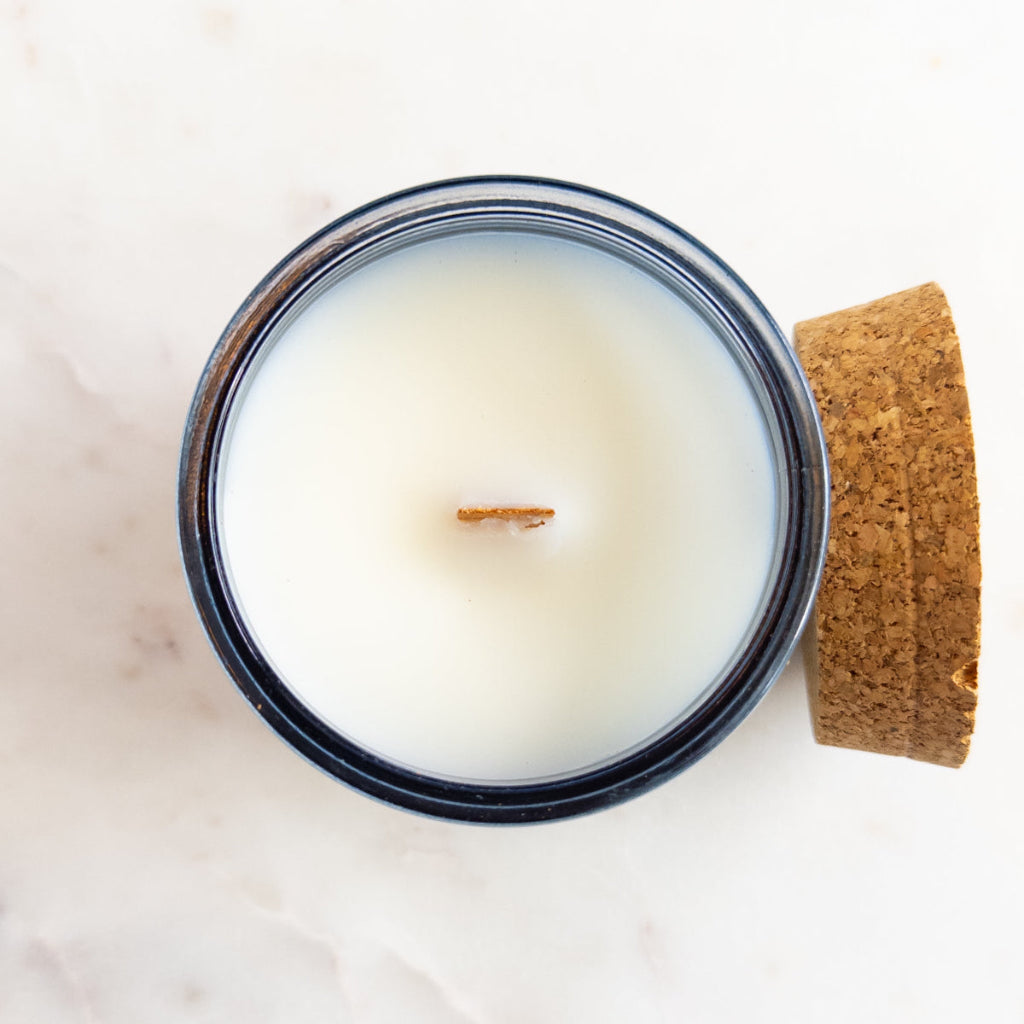 Salem 7.5 oz wood-wick candle in a clear recycled-glass vessel with lid. Olive Grove 7.5 oz wood-wick candle in a recycled-glass vessel.