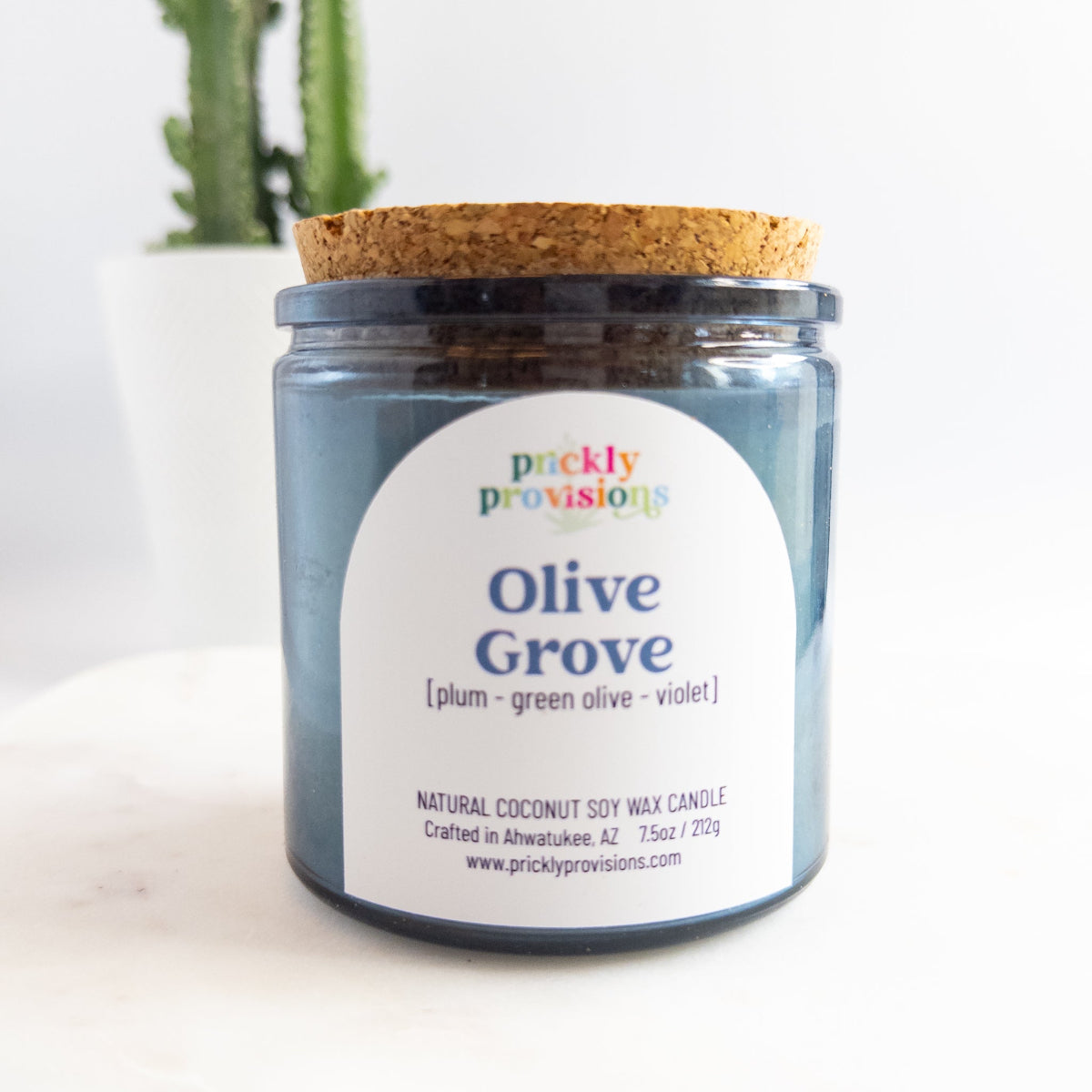 Jar candle labeled 'Olive Grove' by Prickly Provisions on a white background