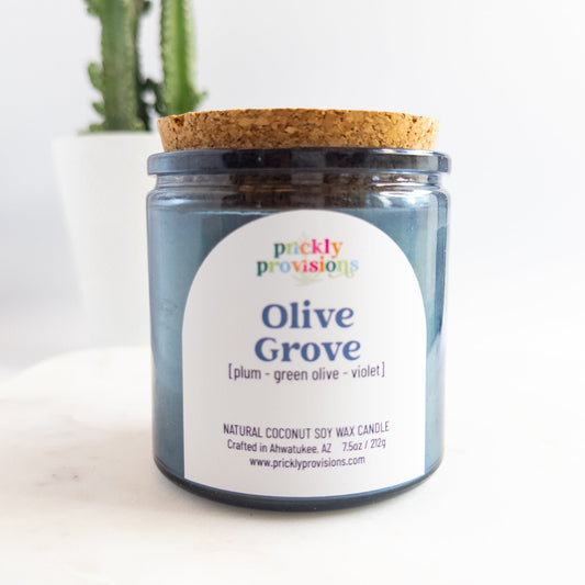 Jar candle labeled 'Olive Grove' by Prickly Provisions on a white background