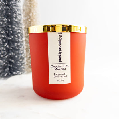 Red candle with a gold lid and white label on a white background