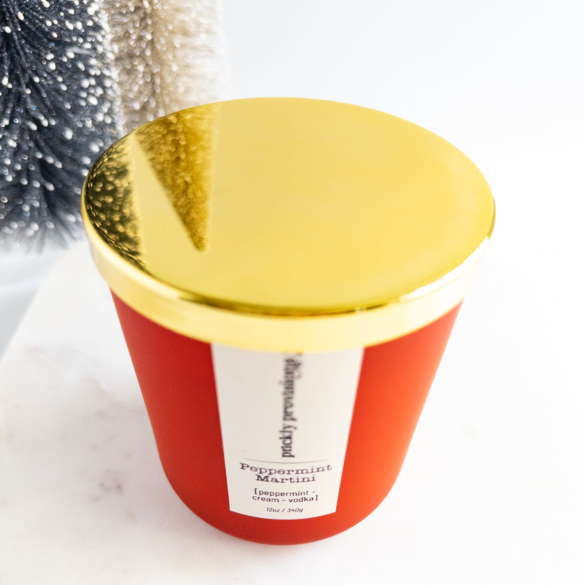 Red candle with gold lid on a white background