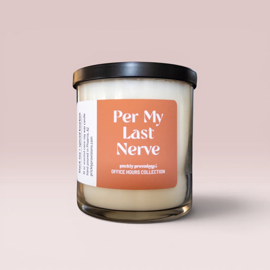 A glass jar candle with a black lid and a peach-colored label reading 'Per My Last Nerve' and 'office hours collection' on a soft pink background.