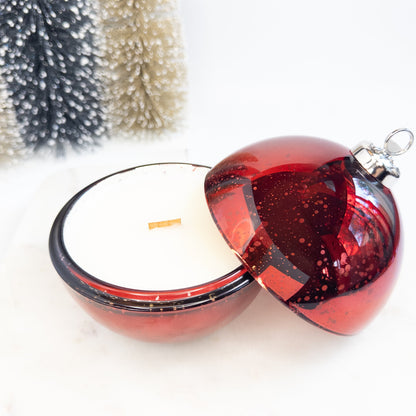 Red glass Christmas ornament candle on a white surface