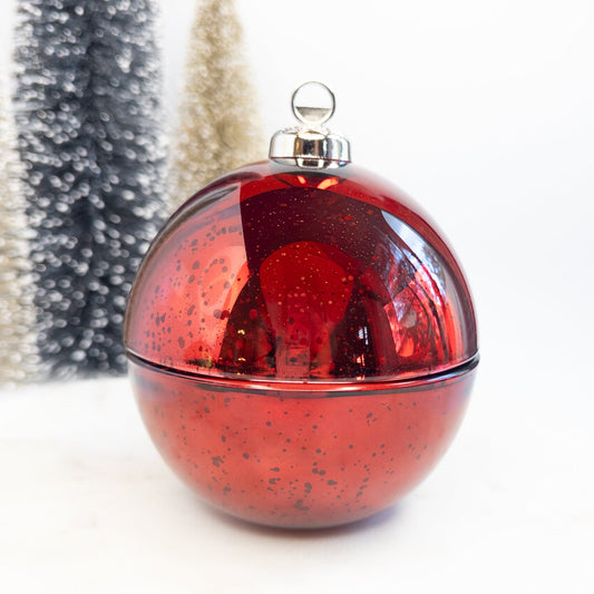 Red glittery Christmas ornament candle with a silver cap on a white background