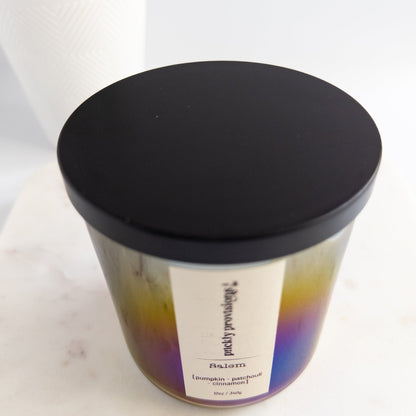 Candle with a black lid on a white marble surface