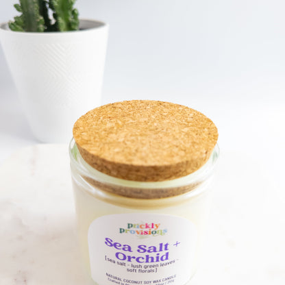 Candle jar with cork lid labeled 'Sea Salt Orchid' from ' prickly provisions' on a white background.